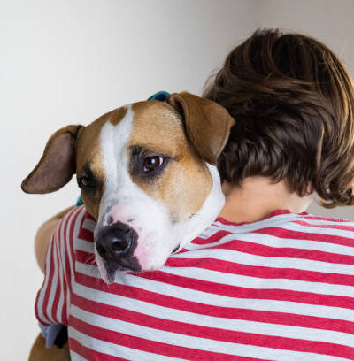 Woman hugs her dog in studio background